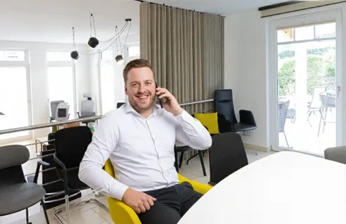 Michael Schesny am Telefon in der Ausstellung von Grothe Büro & Objekteinrichtungen in Hemer 