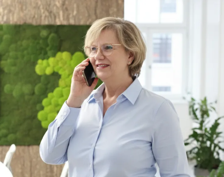 Claudia_beim_Telefonieren Claudia Koch, Assistenz der Geschäftsleitung und Gründerung von Grothe Büroeinrichtungen GmbH beim Telefonieren, Bild ist KI-generiert