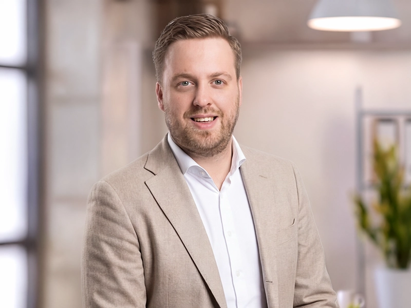 Michael Schesny, Geschäftsführer von Grothe Objekteinrichtungen in Hemer in hellem Anzug in modernem Büro